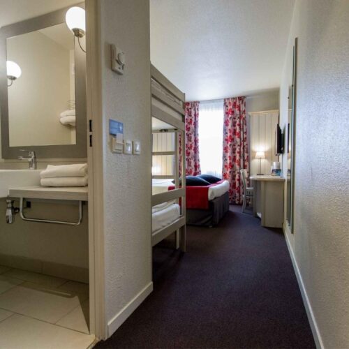 Vierpersoonskamer Campanile Witte badkamer met wastafel en een stapelbed en tweepersoonsbed