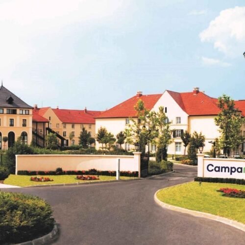 Voorkant Campanile Beigefarbene Gebäude mit roten Dächern und weißer Wand Campanile Val de France