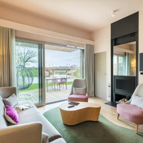 Vierpersoons cottage Wohnzimmer mit Kamin und Terrasse mit Seeblick