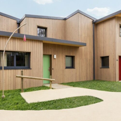 Voorkant huisje Holzhaus mit grüner und roter Eingangstür im Center Parcs Villages Nature Paris