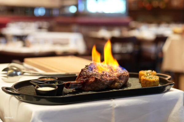 Restaurant Gegrillte Spezialität serviert auf einem eleganten Teller in moderner Umgebung. Frisch gegrilltes Fleisch mit offener Flamme in modernem, eleganten Restaurant.