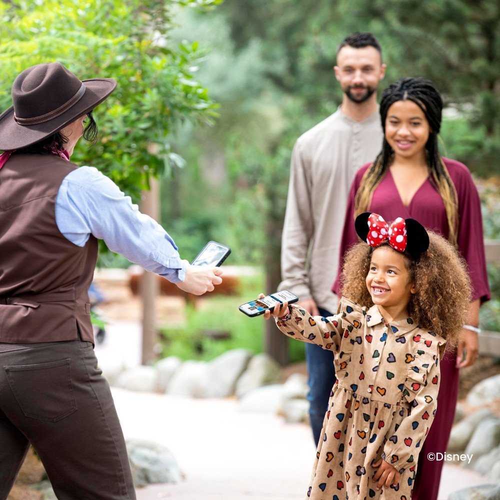 Die Leute lassen ihr Telefon bei einem Cast Member scannen