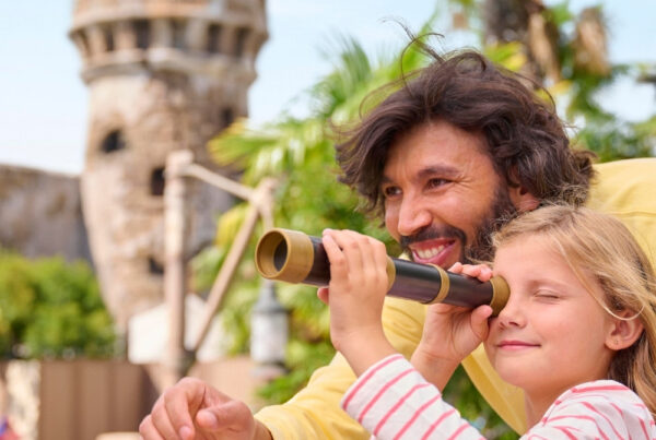 Mann und Kind vor einer der Top 5 Attraktionen, Pirates of the Caribbean
