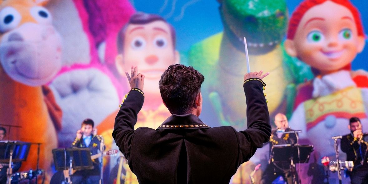 Orchester mit Dirigent vor einer Leinwand mit Disney-Pixar-Figuren